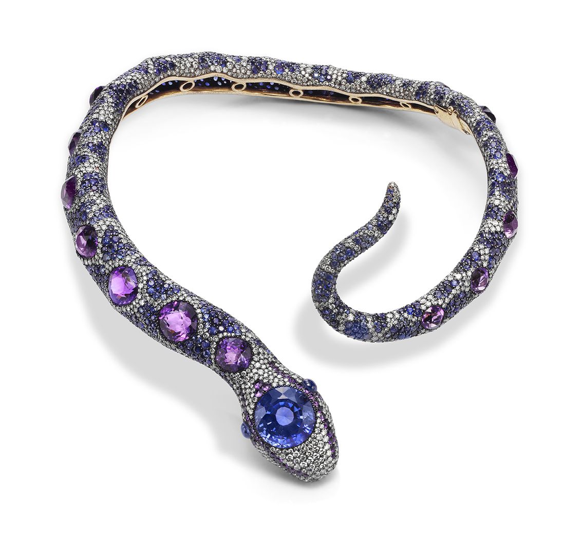 A sinuous snake, with a slightly curved tail (it's almost a closed circle) is studded with many jewels, but most prominently a blueish stone at the snake's head and purple stones down its back
